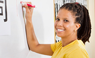 happy female teacher writing on board