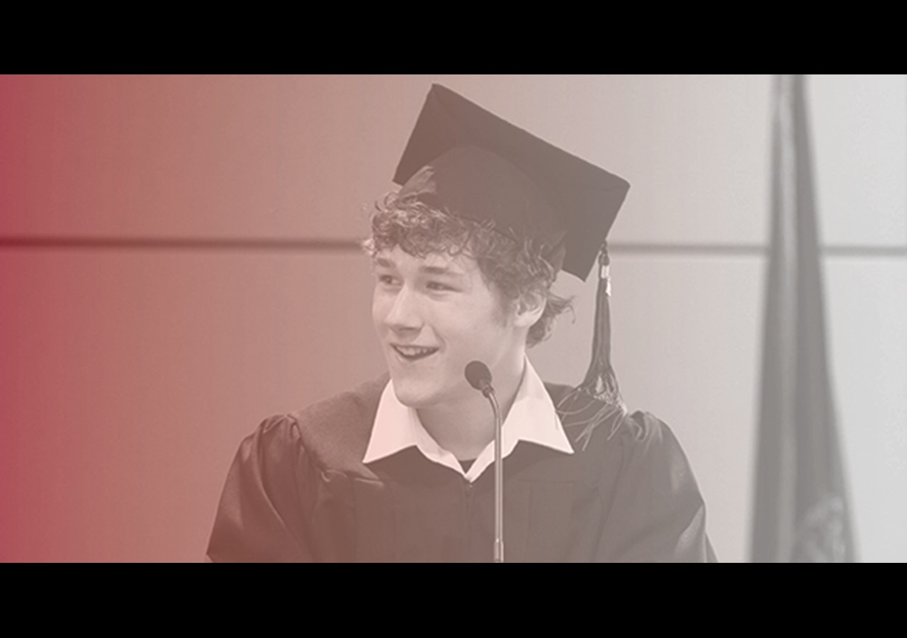 Graduate Expressions image, graduate smiling and speaking at podium photo, Hybrid Graduation Experience 2024