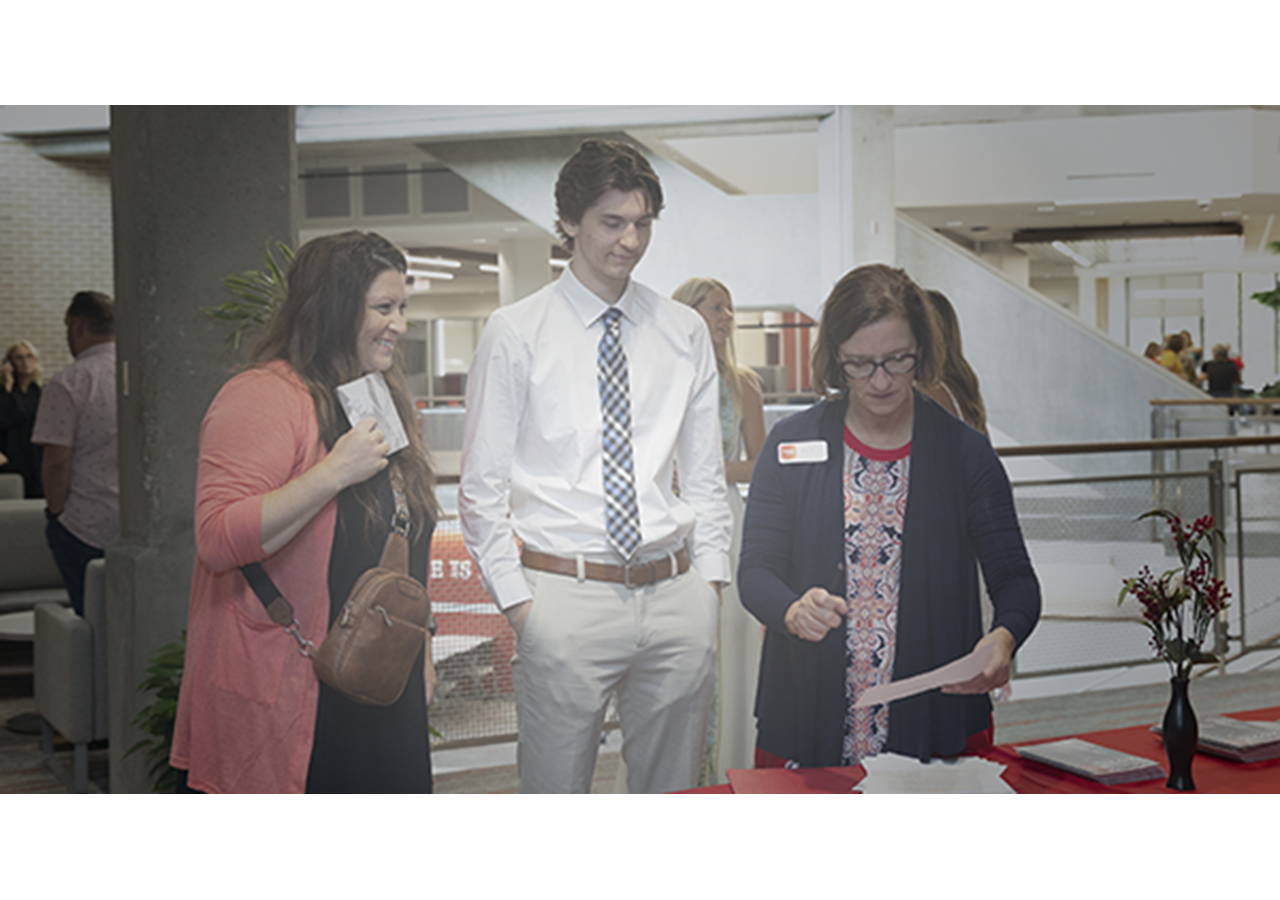Staff Expressions image, graduate and parent talking with UNHS staff member, Hybrid Graduation Experience 2025